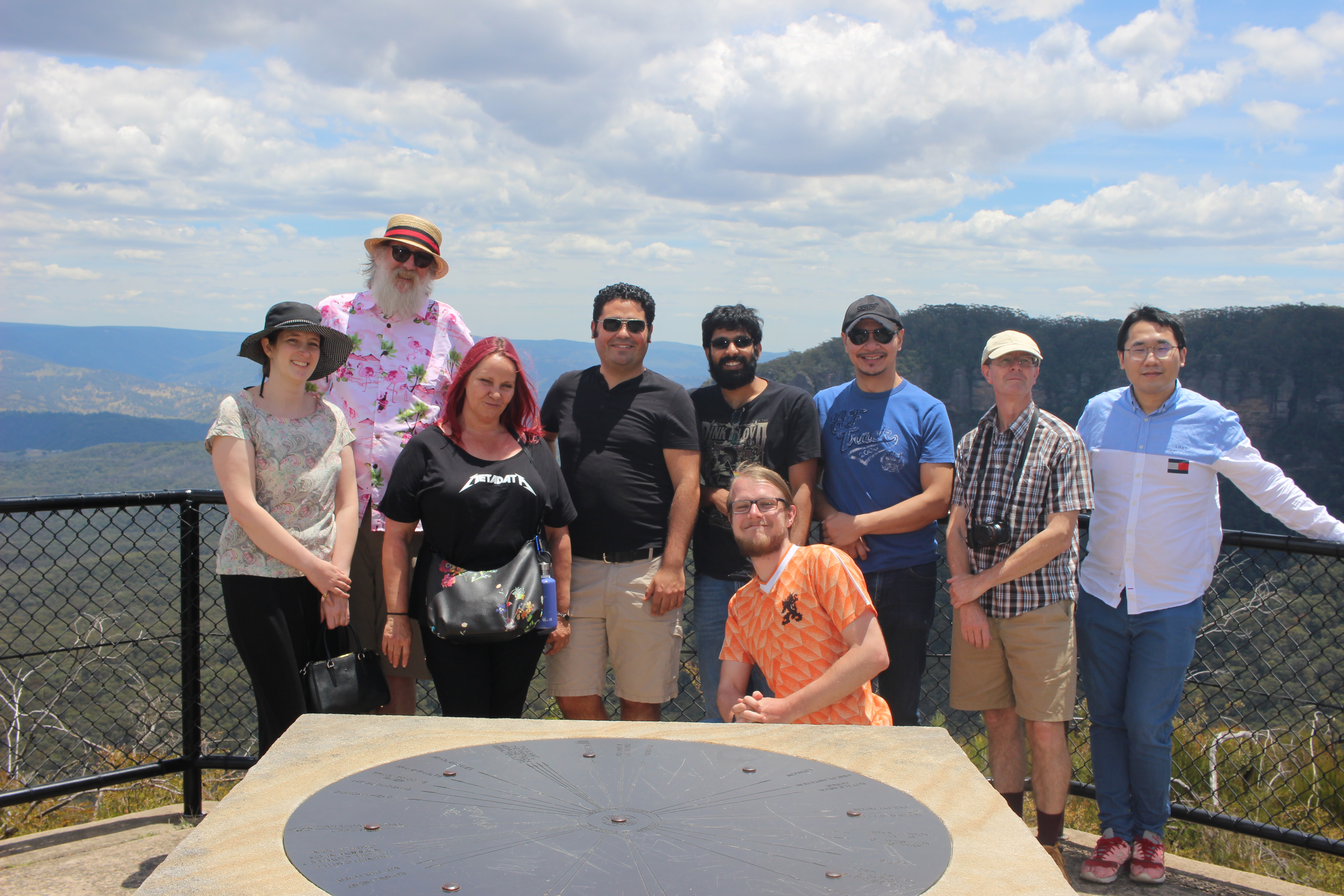 Nine people in front of a valley view